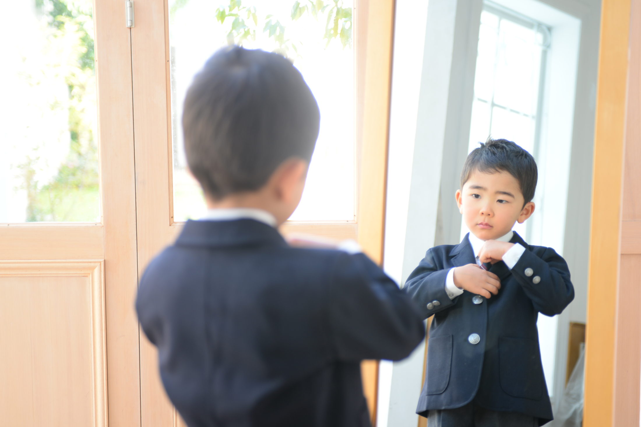 姿見の前で身支度を整える男の子