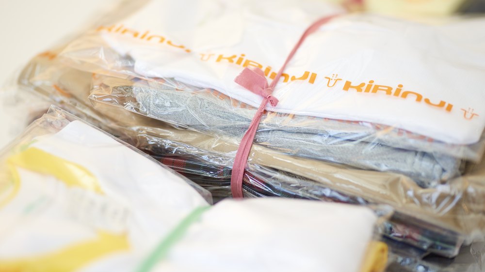 キリンジのリボンで束ねられた、納品前の園児服とグッズ